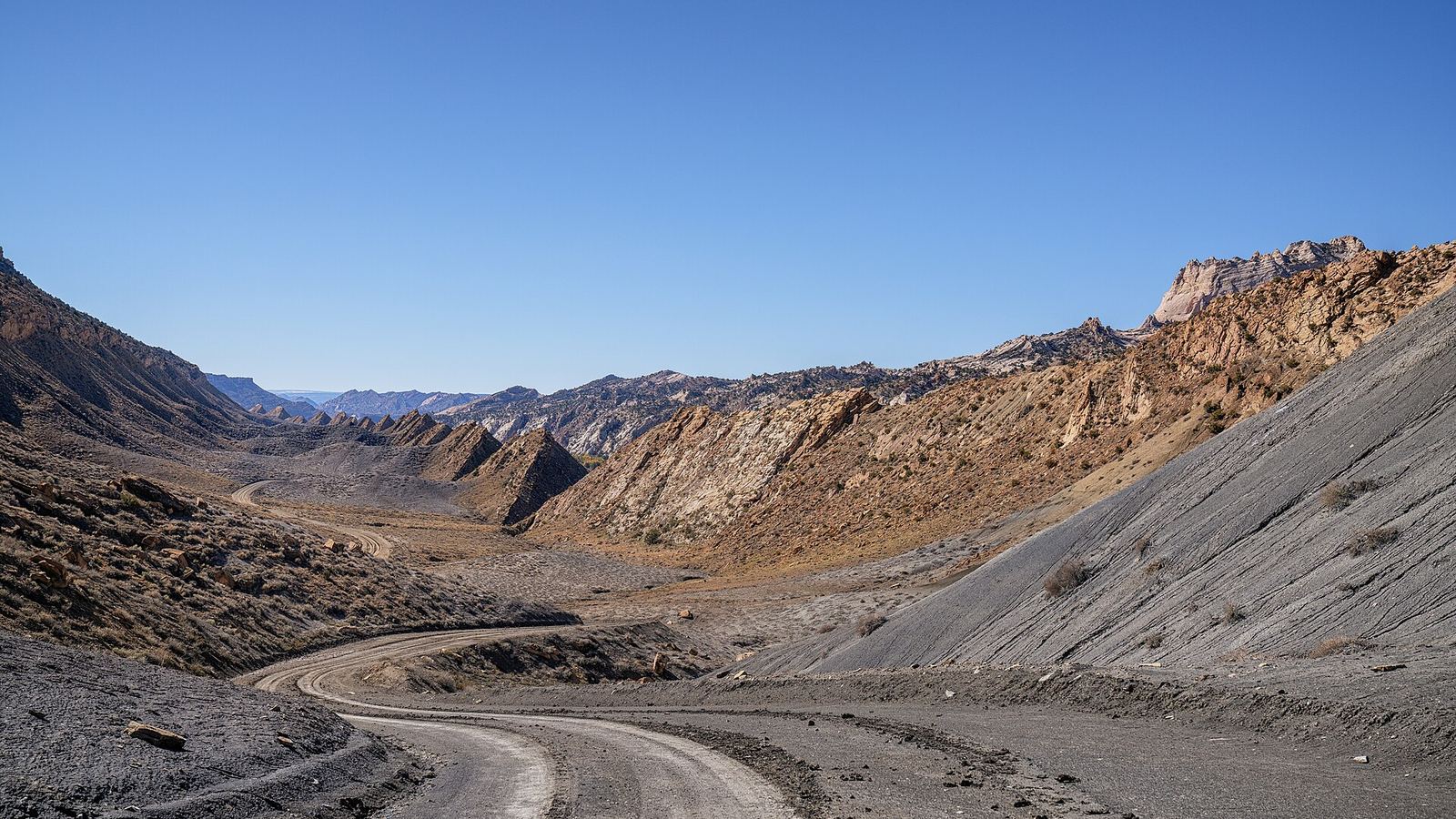 A steep and muddy Cottonwood Canyon Road cuts through the rugged Utah mountains near Paria, Utah.